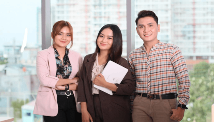 Tiga orang profesional muda berdiri bersama di lingkungan kantor, menggambarkan kesiapan karier di bidang keuangan.